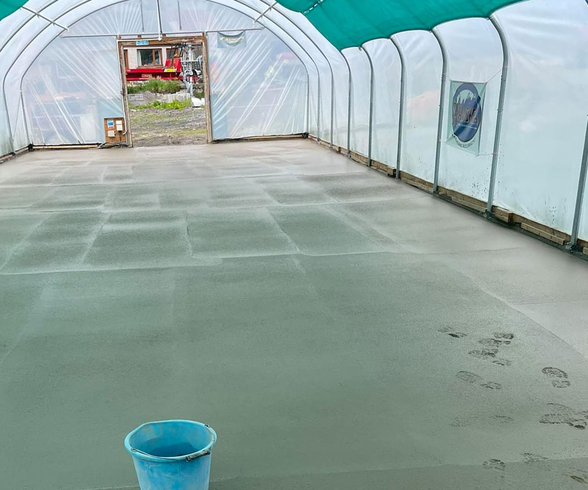 Freshly poured concrete inside a greenhouse